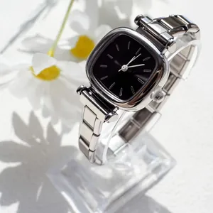 Montre quartz argentée pour femme avec cadran noir minimaliste et détails de marguerites
