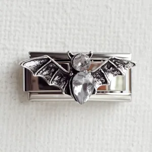 Détail d'un charm chauve-souris en acier inoxydable avec gemmes pour bracelet modulaire