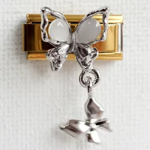 Detail of Italian charm bracelet link featuring a silver butterfly with opal-like stones