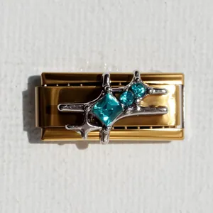 Dettaglio macro della maglia charm italiana placcata in oro con intarsio stella turchese