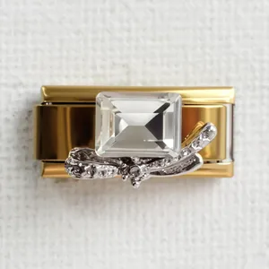 Macro view of modular gold charm link with rectangle crystal and silver dragonfly detail