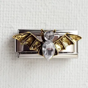 Détail macro d'une breloque chauve-souris noire et dorée avec cristaux pour bracelet