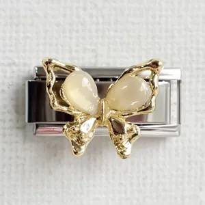 Detailed close-up of a golden butterfly charm link with opal-like stones for Italian bracelet
