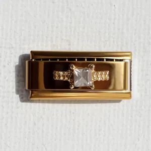 Dettaglio macro di un charm italiano dorato con zircone quadrato e finitura lucida