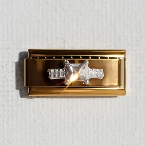 Dettaglio macro di un charm italiano dorato con grande cristallo quadrato e strass pavé