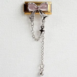 Macro detail of Italian charm link with pink butterfly and silver tassel star charms