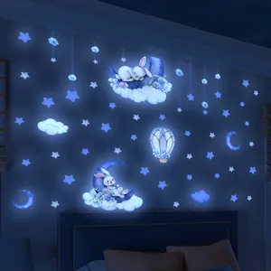 Leuchtende blaue Hasen- und Mondwandaufkleber, die in einem dunklen Schlafzimmer strahlen