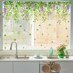 Detail of purple wisteria flower stickers on glass window with a garden background