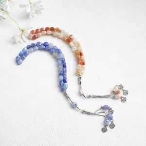 Detalle de pulseras Tasbih hechas a mano con 33 cuentas y borlas de metal plateado
