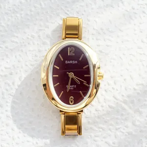 Elegant gold quartz watch with oval burgundy dial and metallic expansion band for women