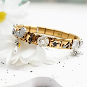 Macro detail of 304 stainless steel Italian charm bracelet with pearl flowers and music charms