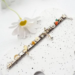 Detail of Italian charm bracelet with enamel star, flower, and music note pendants