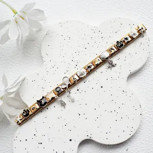 Macro detail of Italian charms bracelet in gold finish with flower and star pendants