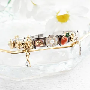 Detail of Italian charm bracelet links featuring gold charms and enamel floral motifs