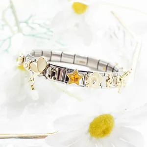 Macro shot of Italian charm bracelet links featuring gold enamel stars and music notes