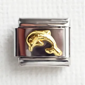 Macro detail of Italian charm bracelet link with gold dolphin on stainless steel base