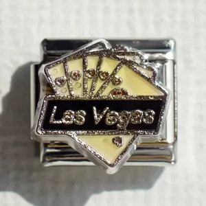Detalle de dije Las Vegas con purpurina dorada en pulsera de acero inoxidable