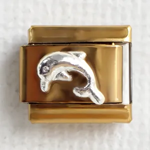 Detailed close-up of a gold Italian charm featuring a 3D silver dolphin relief carving