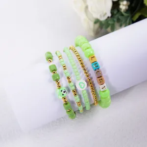 Green bohemian beaded bracelet set featuring Lucky letters, heart bead, and bear charm