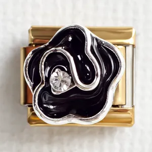 Detailed macro view of a gold Italian charm link featuring a black enamel rose and zircon