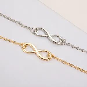Détails des bracelets avec symbole infini en or et argent sur une chaîne minimaliste