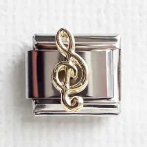 Detailed close-up of a 9mm silver stainless steel Italian charm with a golden treble clef