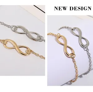 Détail macro du symbole de l'infini poli sur les bracelets en chaîne dorée et argentée