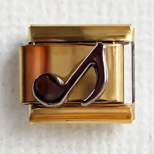 Macro detail of gold 304 stainless steel Italian charm featuring a black music note motif