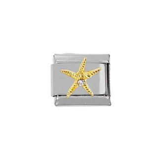 Macro detail of Italian charm bracelet module with golden starfish and inset zircon stone