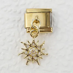 Macro view of gold Italian charm link featuring a sparkling sunburst pendant with zircons