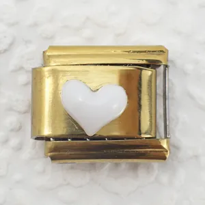 Detail view of Italian charm link featuring gold base and white enamel heart inlay