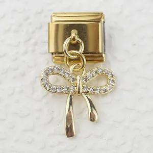 Macro shot of gold Italian charm link featuring a sparkling crystal-encrusted ribbon bow
