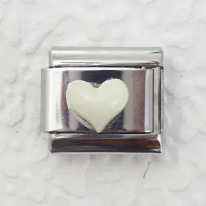 Close-up of a silver stainless steel modular charm with a creamy white heart inlay