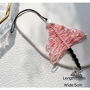 Detail van handgeweven roze kerstboom hanger met witte parels en sterren versiering