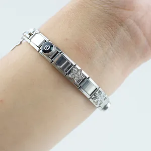 Dettaglio di un bracciale modulare argento con ciondoli stella, fiocco e numero 8 biliardo