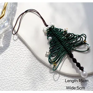 Detail van handgemaakte gevlochten kerstboom hanger met witte strik en gouden ster bedeltje
