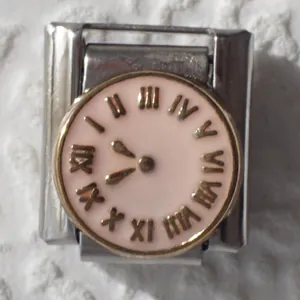 Macro shot of Italian charm link featuring a pink enamel vintage clock face design