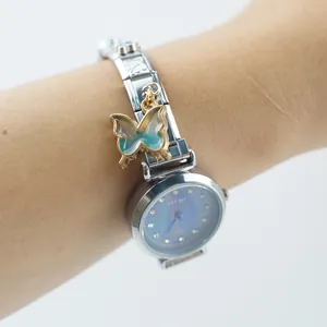 Dettaglio dell'orologio argento con quadrante in madreperla blu e ciondolo farfalla