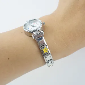 Dettaglio dell'orologio argento con indici colorati e ciondolo a stella gialla al polso