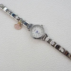 Dettaglio dell'orologio in argento con quadrante in strass e ciondoli a unicorno
