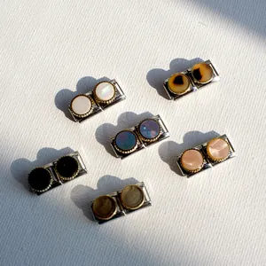 Detail of modular bracelet charms with mother of pearl and tortoise resin insets