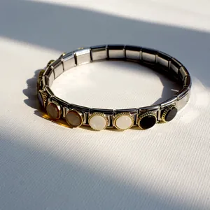 Detailed macro shot of Italian charm bracelet links with inlaid mother of pearl gems