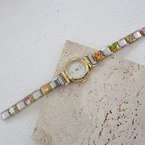 Dettaglio orologio quarzo donna con ciondoli smaltati colorati su cinturino oro e argento