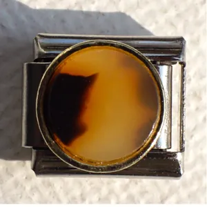 Detail of Italian modular bracelet link with stainless steel and amber resin inlay
