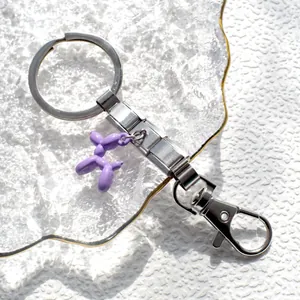 Dettaglio del portachiavi in acciaio inox con cane palloncino viola su vassoio
