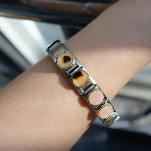 Italian modular stainless steel bracelet with shell round charms on a model's wrist