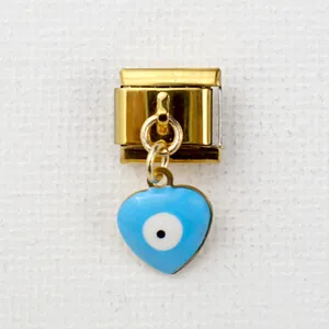 Macro shot of Italian gold link charm with blue heart-shaped enamel evil eye pendant