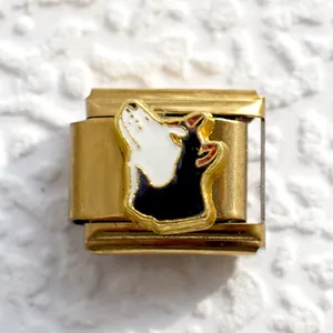 Macro shot of gold Italian charm link with black and white wolf head enamel detailing