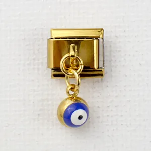 Detailed macro view of golden Italian style link charm with a blue evil eye pendant