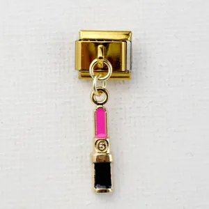 Makroaufnahme eines goldenen Italian Charm Moduls mit einem pink-schwarzen Lippenstift